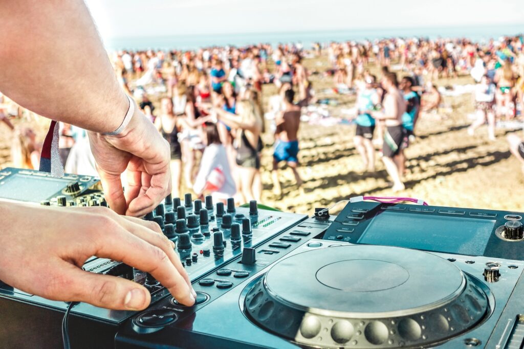 Detail of dj playing modern sound on cd usb player at spring break festival - Beach music party and life style concept - Defocused background with shallow depth of field - Bright vivid filter